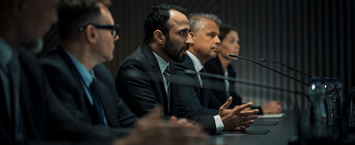 A panel of government officials at a public meeting